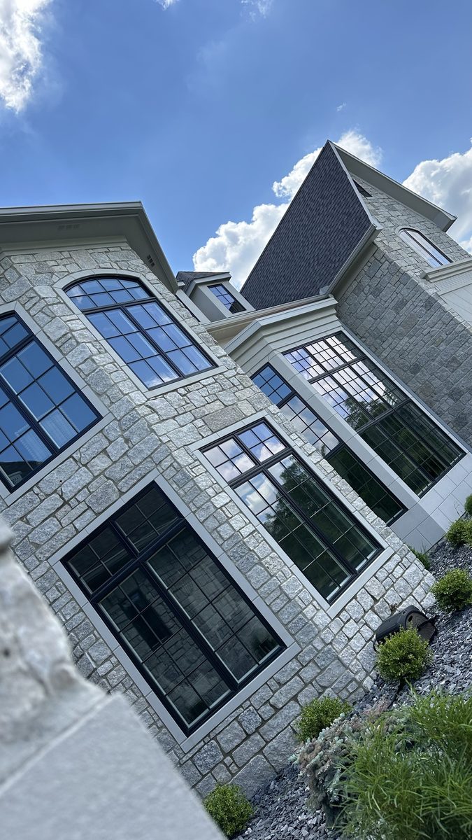 Upward view of stone estate home windows